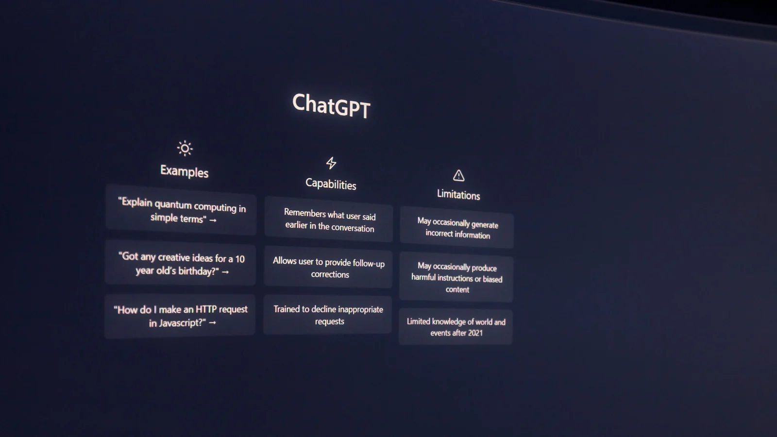 A dark computer monitor displays a ChatGPT welcome screen.